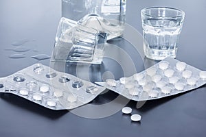 Drug abuse: Close up of pills and alcohol on a grey table