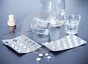Drug abuse: Close up of pills and alcohol on a grey table