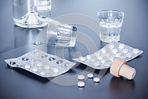Drug abuse: Close up of pills and alcohol on a grey table