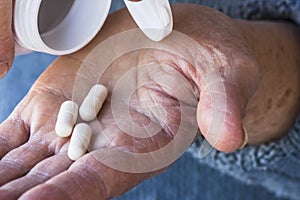 Drug pills on old woman`s hand