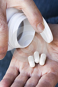 Drug pills on old woman`s hand