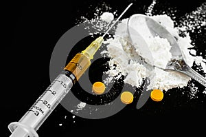 Drug syringe, amphetamine tablets and cooked heroin.