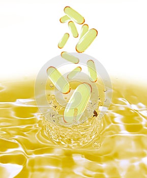 Drug yellow capsule fish oil omega3 droping in oil water. photo