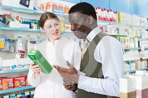 druggist explaining prescribed medicine to man
