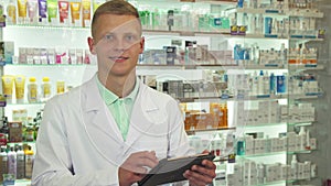 Druggist using tablet and smiling at camera close up