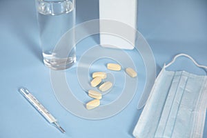 Drugs with thermometer and mask with glass of water