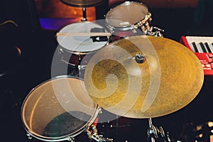 Drum set in dramatic light on a black background.