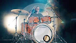 Drum set, drum kit in dark, drummer plays a concert. A man is enjoying his drumming rehearsals