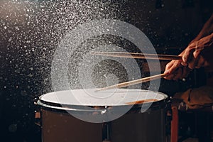 Drum sticks drumming beat rhythm on drum surface with splash water drops