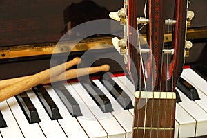 Drum sticks, guitar and piano keyboard