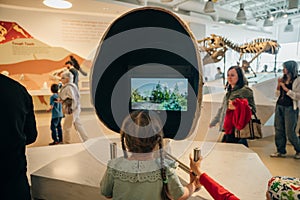 Drumheller, Canada - Mar 2023 Visitors flock to the dinosaur exhibits at the entrance of the Royal Tyrrell Museum