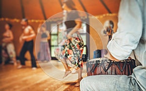 Drummer playing the djembe at the cacao ceremony. Ceremony dance in circle. Ceremony space.