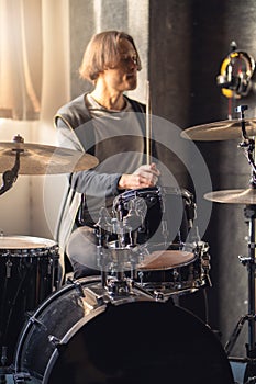 Drummer is playing musical instrument drum, with drumhead and cymbal in sound recording studio photo