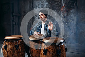 Drummer playing on wooden bongo drums, beat rhythm