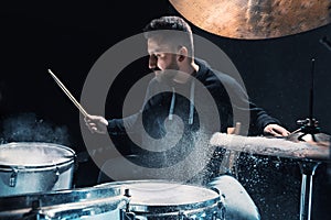 Drummer rehearsing on drums before rock concert. Man recording music on drum set in studio
