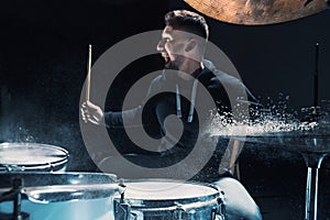 Drummer rehearsing on drums before rock concert. Man recording music on drum set in studio