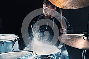 Drummer rehearsing on drums before rock concert. Man recording music on drum set in studio