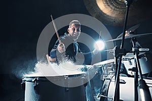 Drummer rehearsing on drums before rock concert. Man recording music on drum set in studio