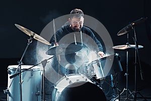 Drummer rehearsing on drums before rock concert. Man recording music on drum set in studio