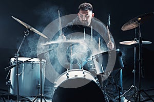 Drummer rehearsing on drums before rock concert. Man recording music on drum set in studio