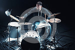 Drummer rehearsing on drums before rock concert. Man recording music on drum set in studio