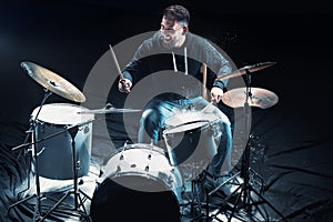 Drummer rehearsing on drums before rock concert. Man recording music on drum set in studio