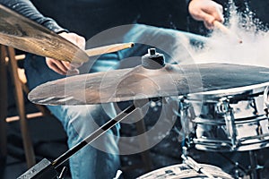 Drummer rehearsing on drums before rock concert. Man recording music on drum set in studio