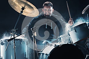 Drummer rehearsing on drums before rock concert. Man recording music on drum set in studio