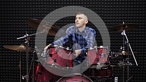 Drummer is tuning drum kit in professional rehearsal studio. Professional musician tunes drum cymbals in concert hall. Music conce