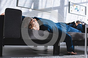 drunk businessman sleeping on sofa