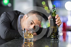 Drunk businessman slumped on bar