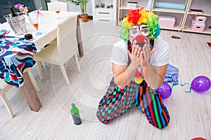 The drunk clown celebrating having a party at home