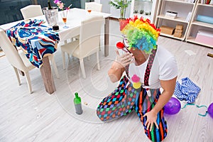 The drunk clown celebrating having a party at home