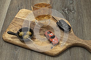 Drunk driving concept - car keys in the foreground with glass of whiskey