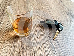 Drunk driving concept. Glass with whiskey and car key on the table.