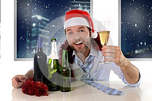 Drunk happy business man in Santa hat with alcohol bottles in new year toast with champagne glass