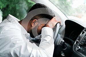 Drunk indian man slumped on steering wheel in his car photo