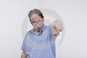 A drunk and inebriated middle aged man pointing to the camera while slurring his speech. Isolated on a white backdrop