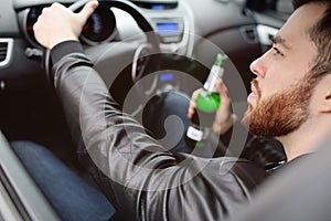 Drunk man with a bottle of beer driving a car