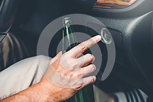 Drunk man driving a car on the road holding bottle beer Dangerous drunk driving concept