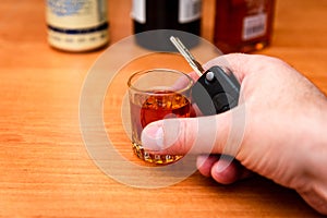 Drunk man hand with glass alcohol,car key in hand taking car keys.Do not drink and drive