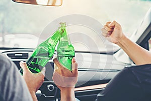 Drunk man party with friends and driving car on the road holding bottle beer Dangerous drunk driving concept