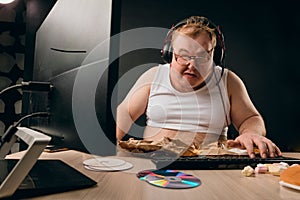 Drunk man sitting at home with computer looking depressed photo
