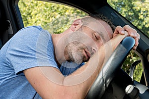 drunk man slumped over steering-wheel photo