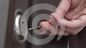 A drunk man tries to get a key into the key slot on the front door to the apartment