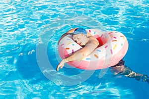 Drunk resting guy on the inflatable circle in the swimming pool of the hotel photo