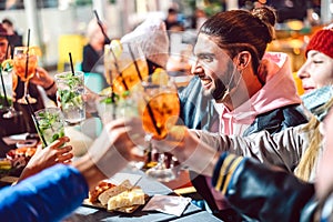 Drunks friends toasting fancy drinks at night bar with open mask - New normal nightlife concept with milenial people having fun