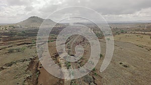 Dry African river bed aerial flyover shot with train tracks in dry season