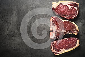 Dry aged beef steaks - ribeye, striploin, t-bone steaks on Black