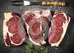 Dry aged beef steaks - ribeye, striploin, t-bone steaks on Black